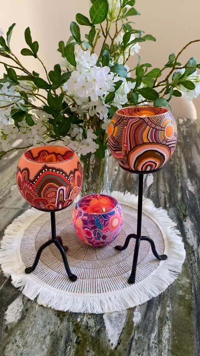 Hand-painted ceramic bowls with colorful dot art patterns on a white fringed mat.