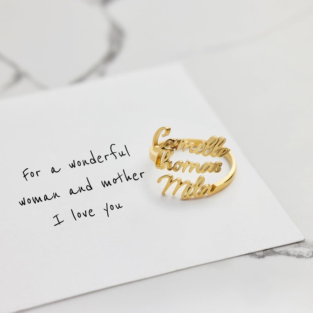 Gold name ring on a white card with a handwritten message for mother.