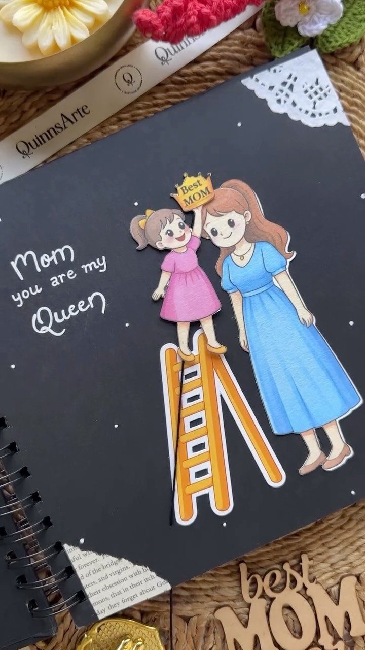 Black scrapbook page with cartoon illustration of a daughter crowning her mother.