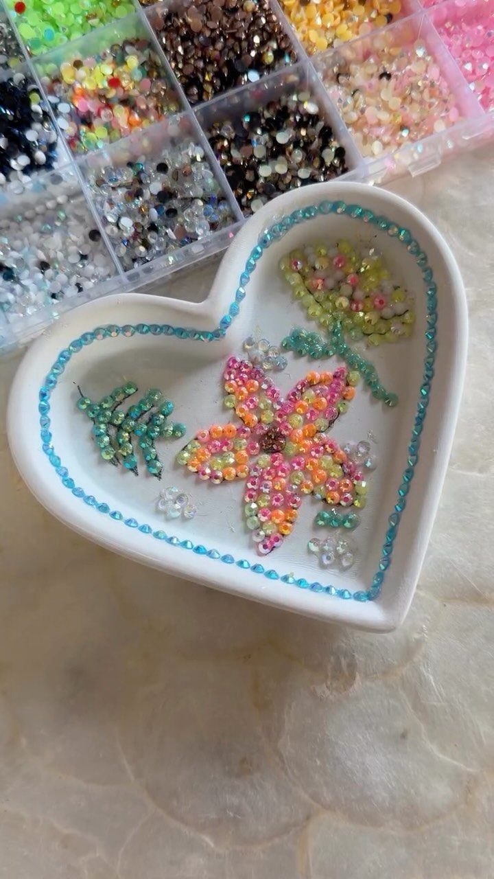 Heart-shaped white dish decorated with colorful rhinestone flowers and leaves