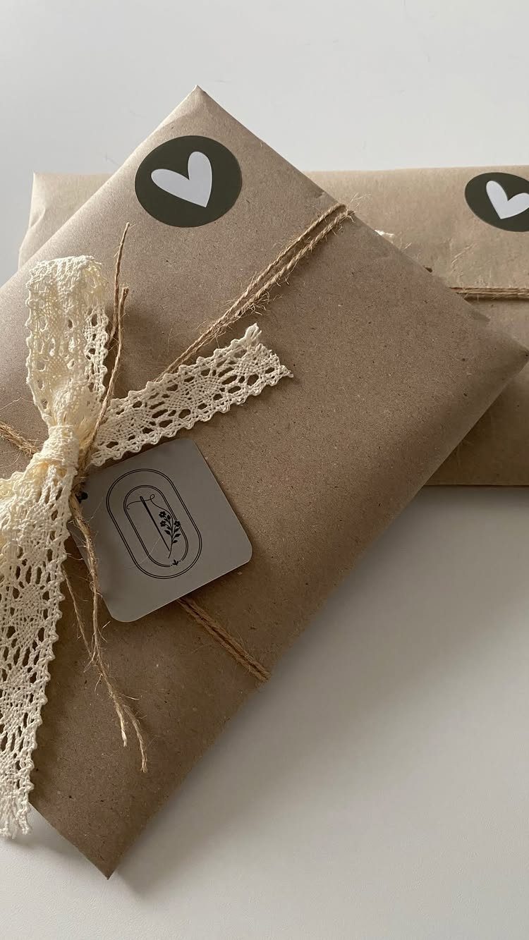 Brown paper wrapped gifts tied with twine and cream lace ribbon and heart stickers