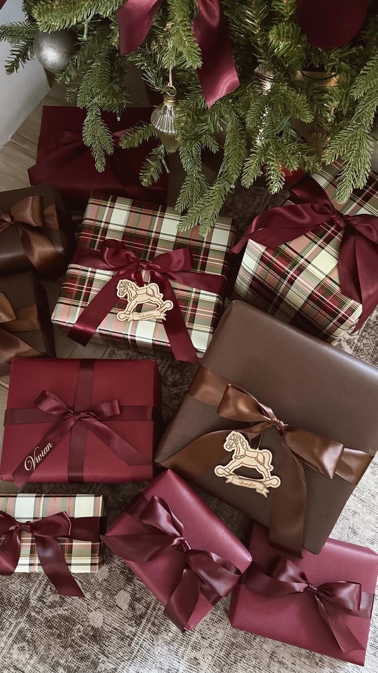 Wrapped gift boxes with ribbons and ornaments under a green Christmas tree
