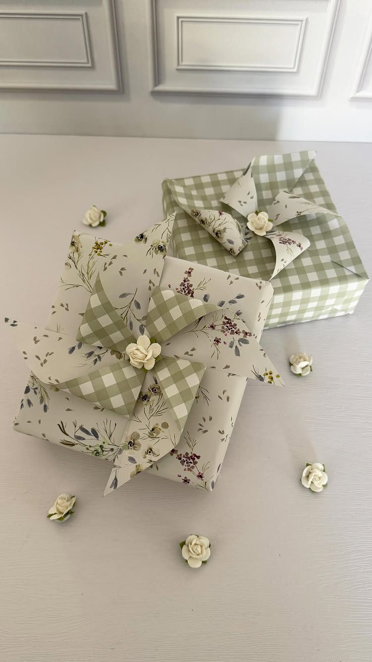 Two wrapped gift boxes with floral and gingham patterns and decorative fabric bows.