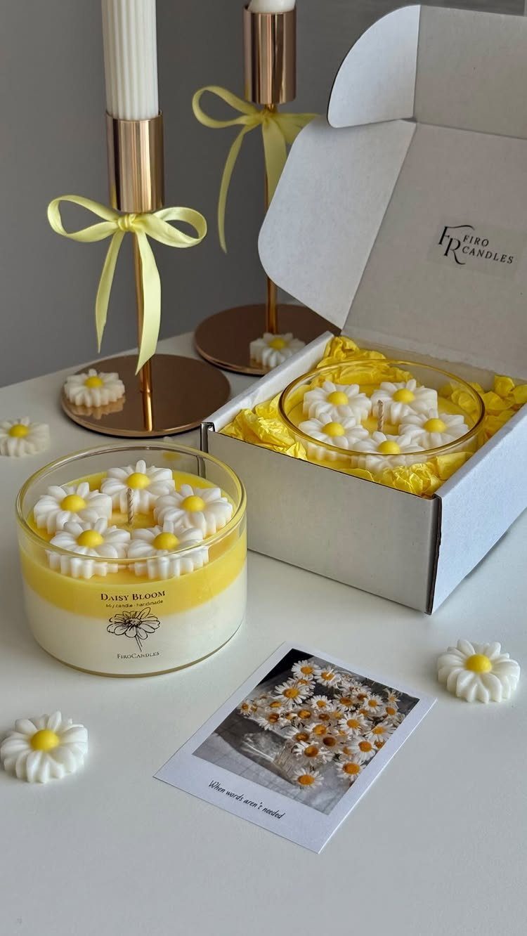 Yellow daisy-themed candles and wax melts in a white gift box with gold accents.