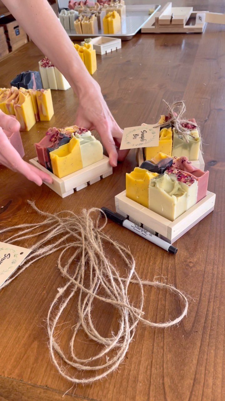 Handmade colorful soap bars on wooden slats with twine and gift tags.