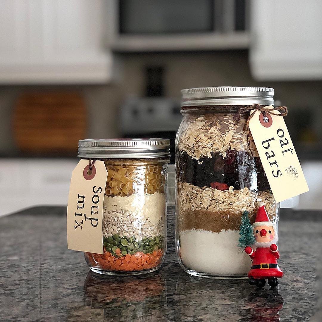 Two glass jars filled with layered dry food mixes on a granite counter.
