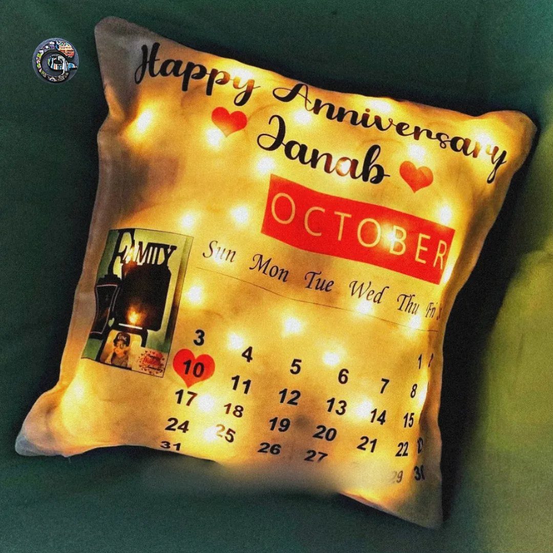 Illuminated white anniversary pillow with an October calendar and red heart accents.