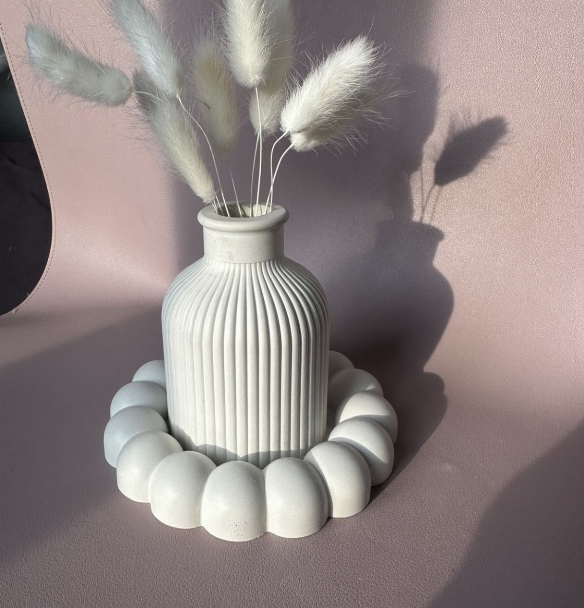 White ribbed vase with pampas grass on a bubble-shaped ceramic tray