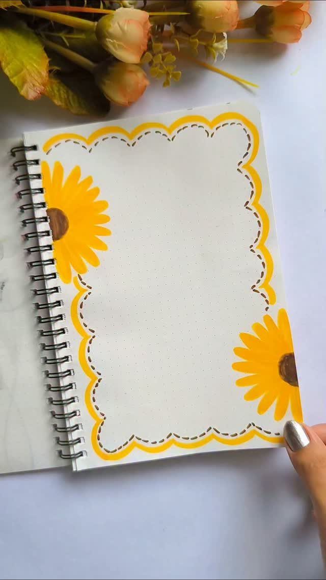 Spiral notebook with hand-drawn yellow sunflowers and a decorative scalloped border.