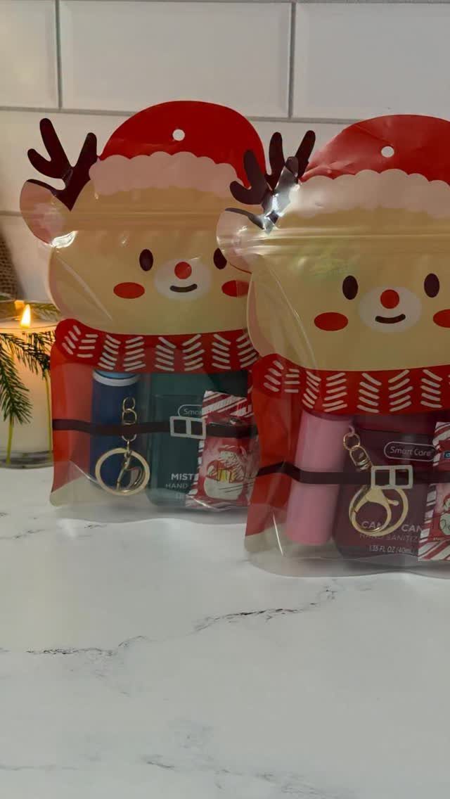 Reindeer shaped gift bags filled with small treats on a white marble surface.