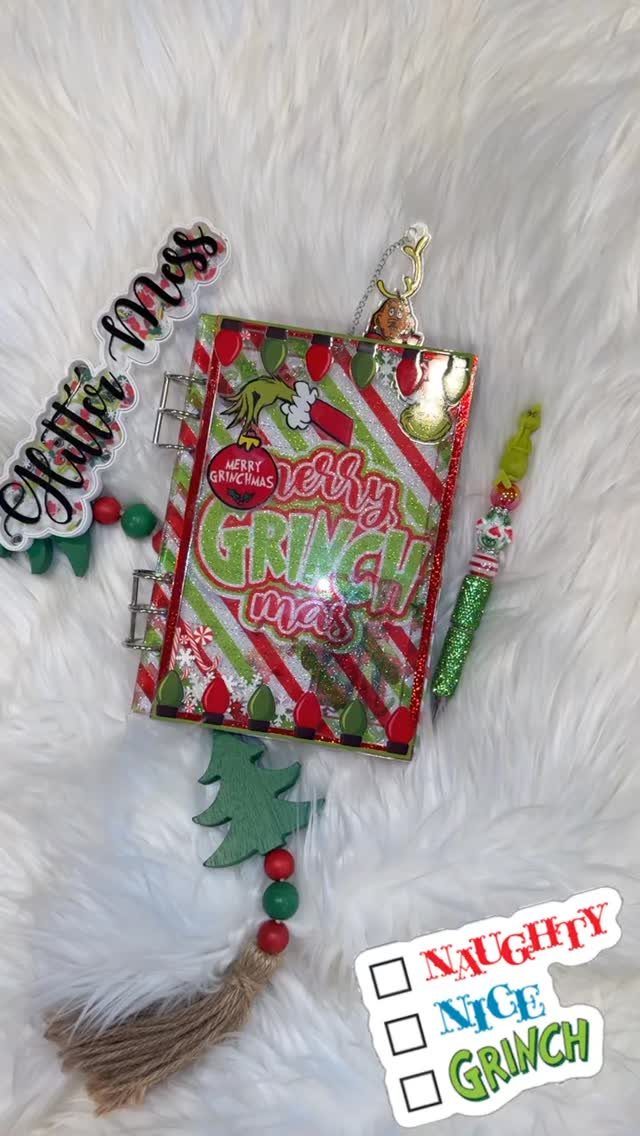 Customized Christmas notebook with Grinch theme on a white fluffy background.