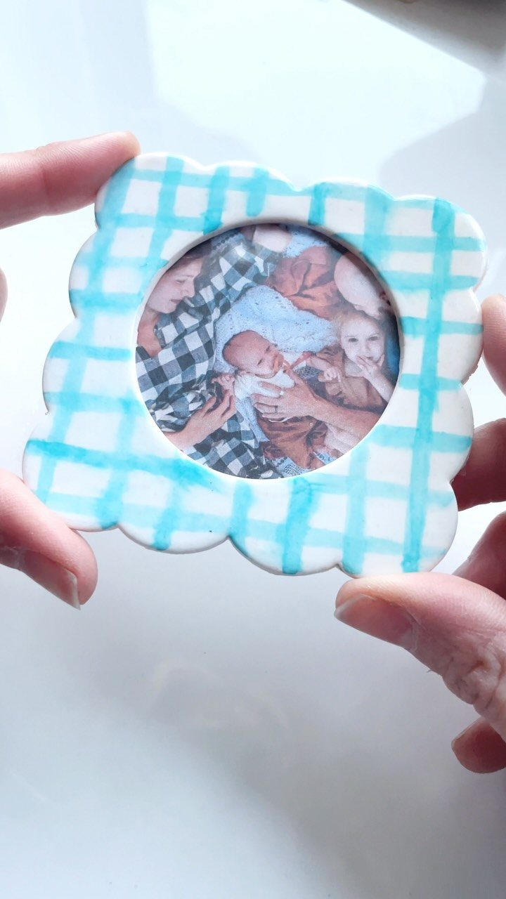 Small ceramic ornament with blue checkered pattern and a family photo center.