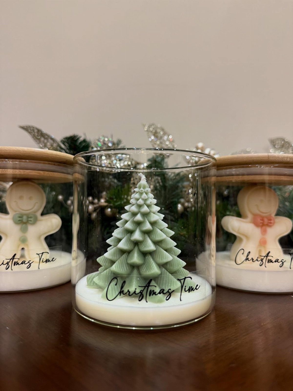 Decorative wax melts in glass jars shaped like a Christmas tree and gingerbread men.
