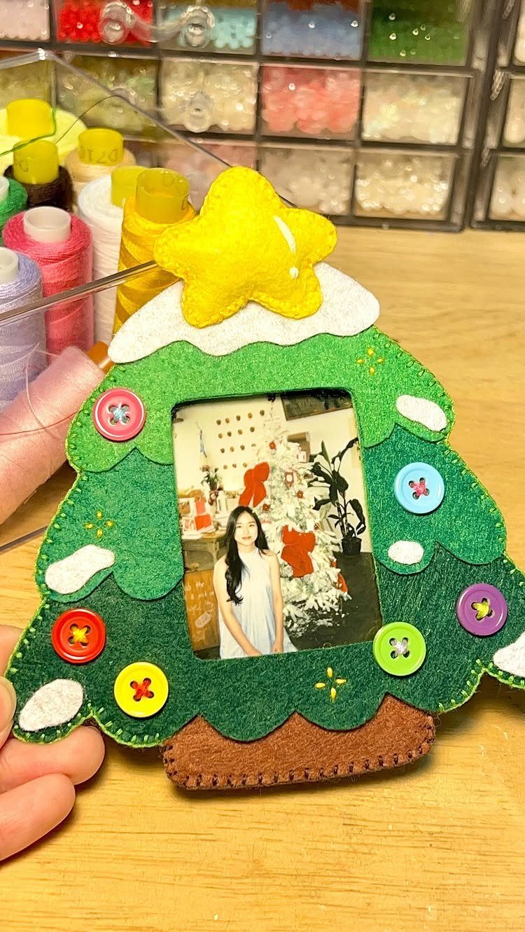 Handmade felt Christmas tree ornament with a photo of a girl and colorful buttons.
