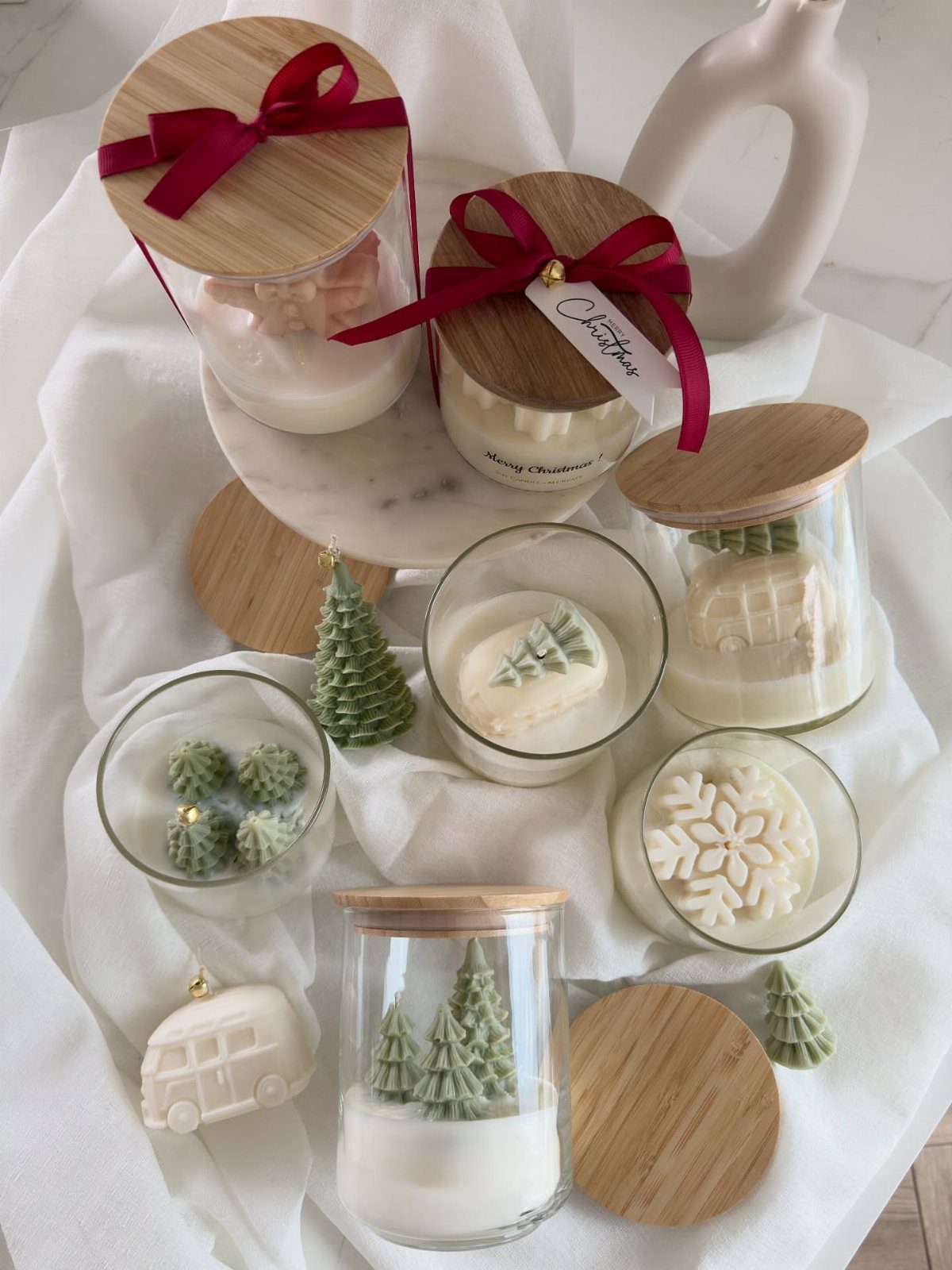 White soy candles in glass jars with bamboo lids and festive wax embeds.