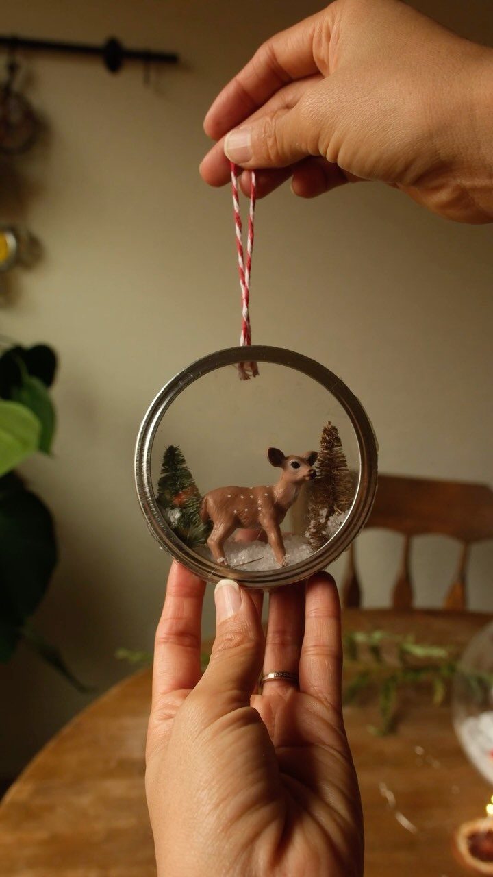 Mason jar ring ornament featuring a small deer and trees in fake snow.