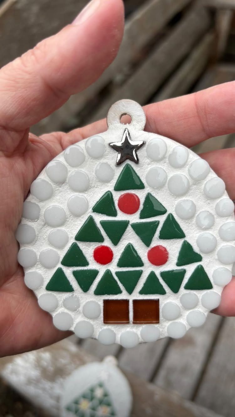 Circular white mosaic ornament featuring a green and red glass tile Christmas tree.