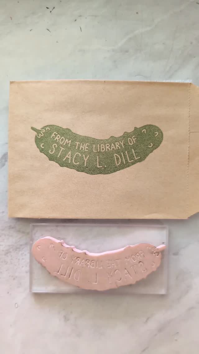 Hand-carved rubber library stamp and its green ink impression on brown paper.