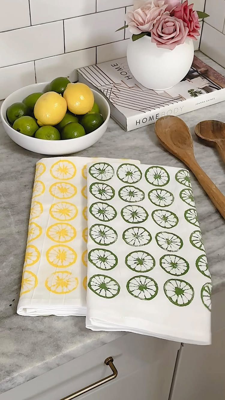 White tea towels with stamped yellow and green citrus slices on marble counter