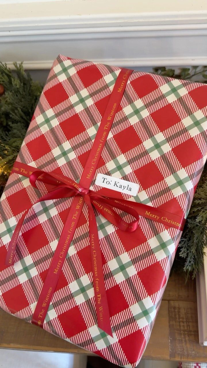 Plaid wrapped gift with a red ribbon and a white label for Kayla.