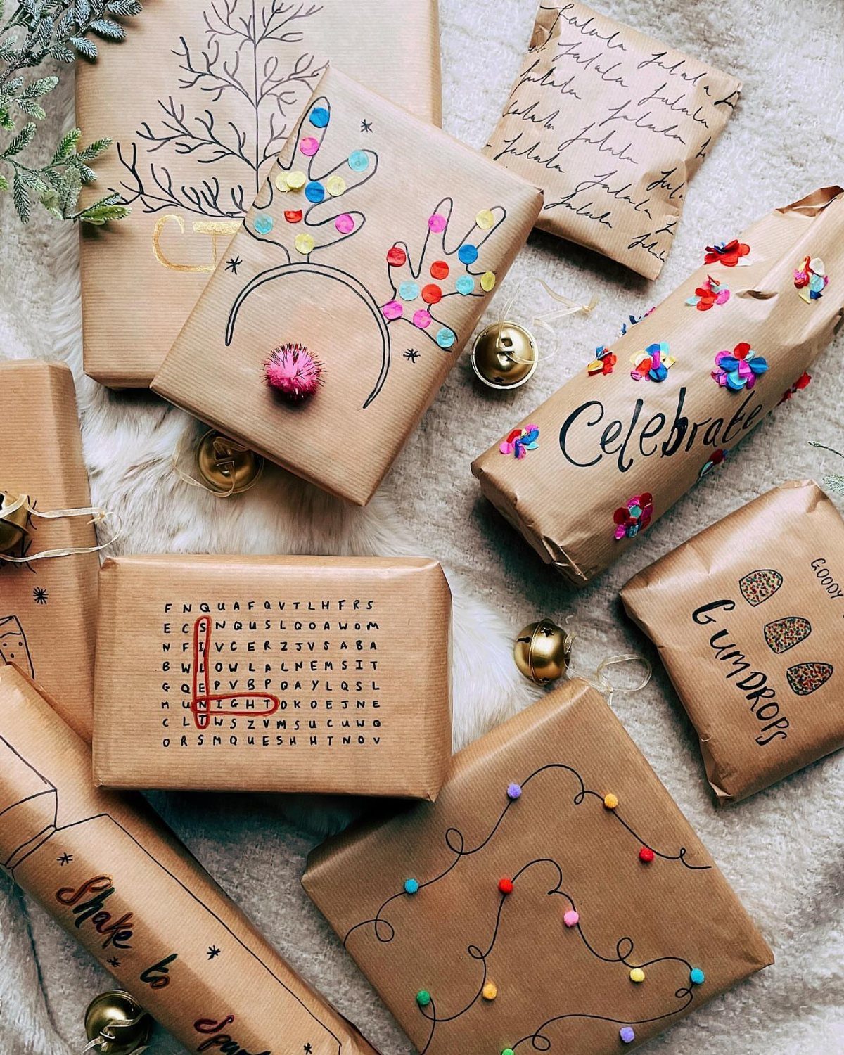 Brown paper wrapped gifts with hand-drawn patterns and colorful dots on white fur.