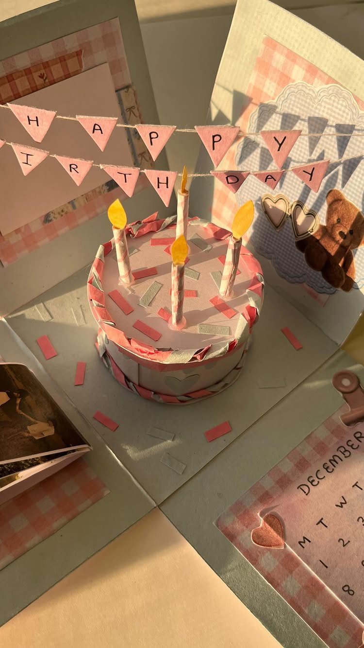 Handmade explosion box with a paper birthday cake and celebratory pink banner.