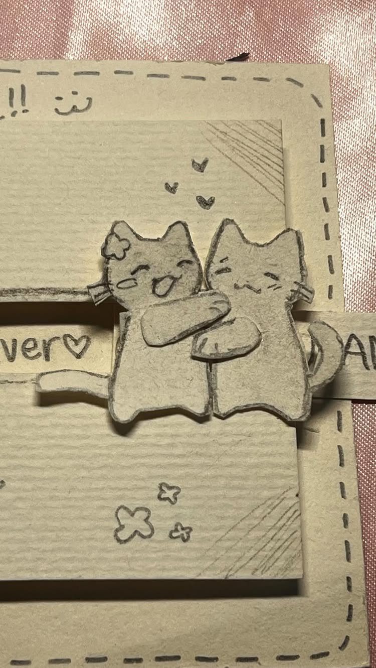 Handmade brown paper card with two cute paper cats hugging and heart doodles.