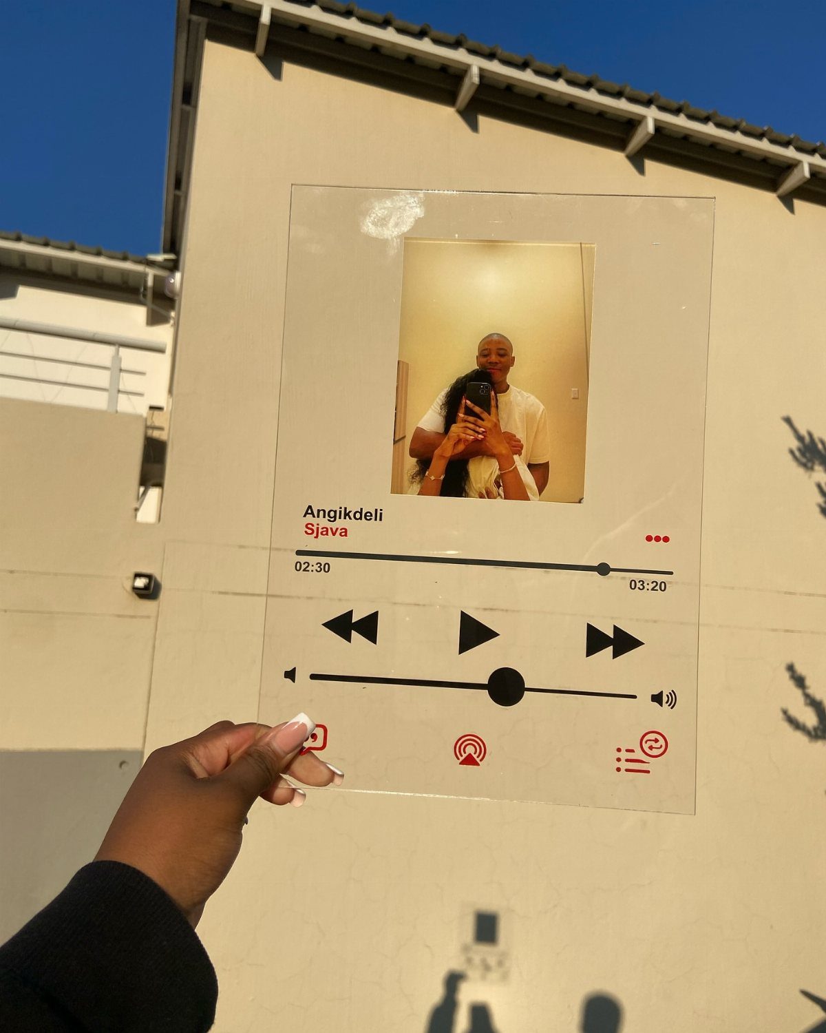 Acrylic song plaque with a couple's photo and music player interface held outdoors.
