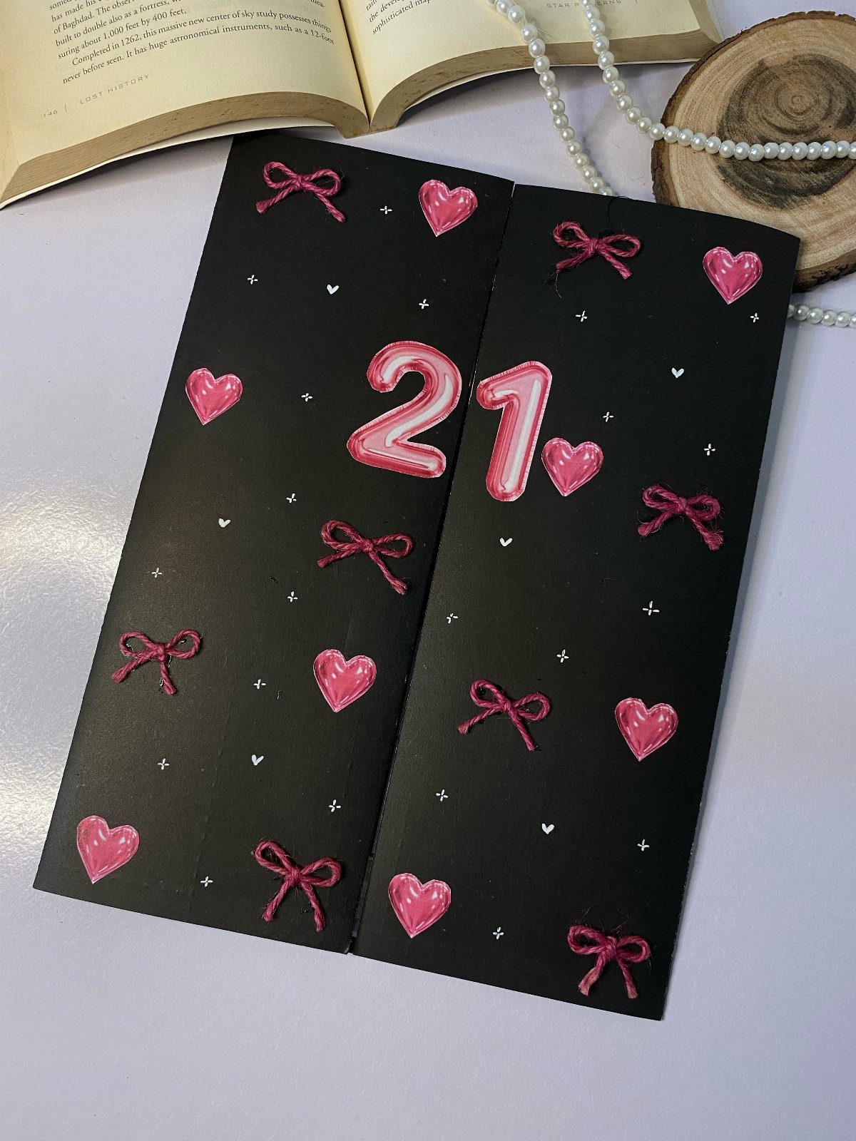 Black birthday cards decorated with pink 3D hearts, bows, and the number 21.