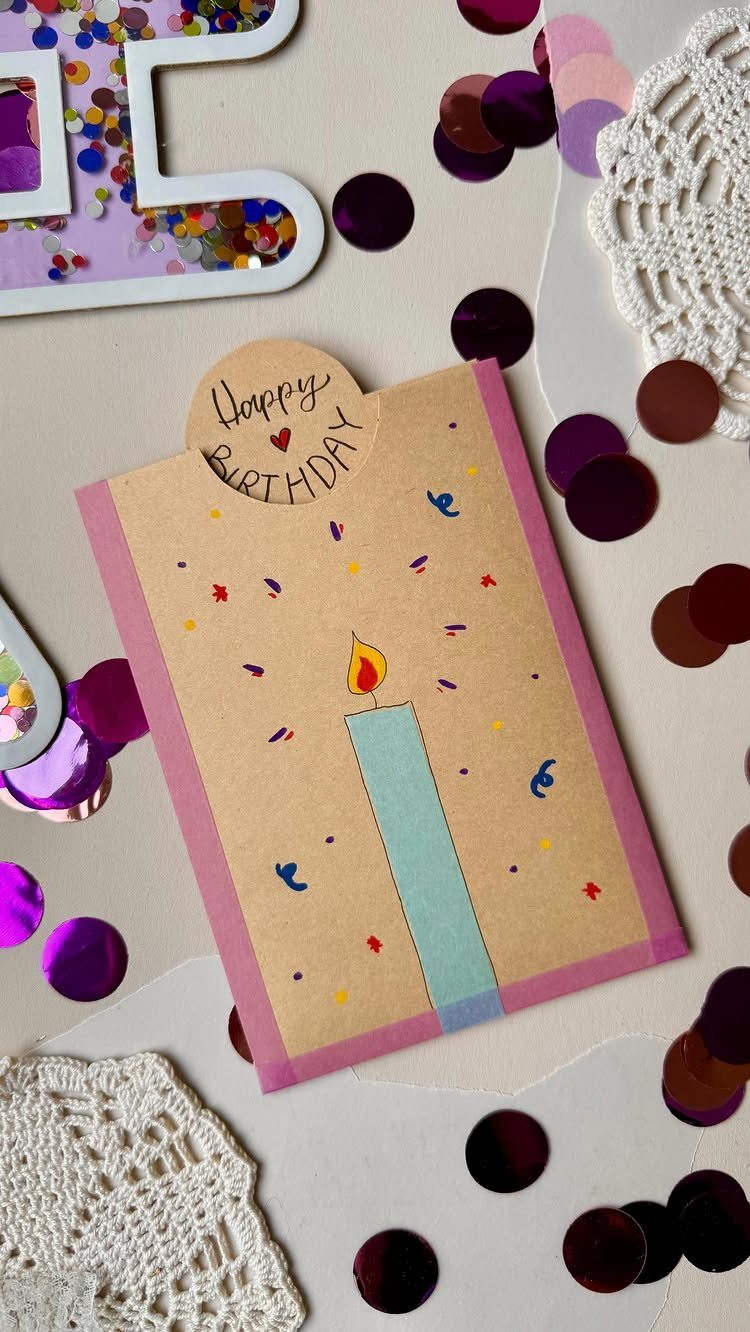 Handmade birthday card with a blue candle illustration and colorful confetti surroundings.