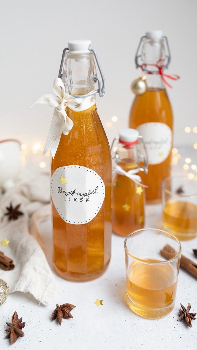 Amber liqueur in glass swing-top bottles with cinnamon sticks and star anise.