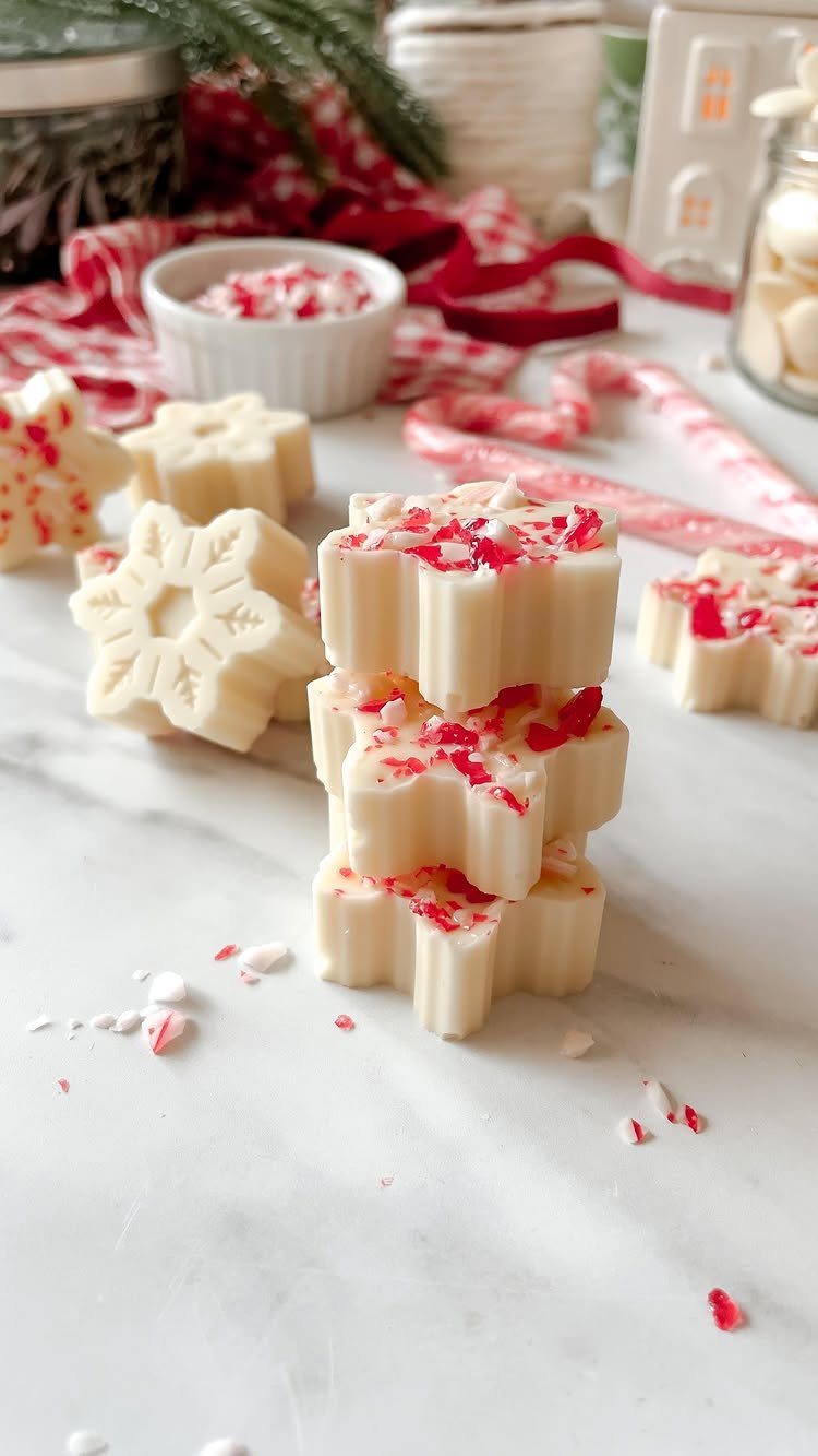 White chocolate snowflake treats topped with crushed peppermint on a marble surface