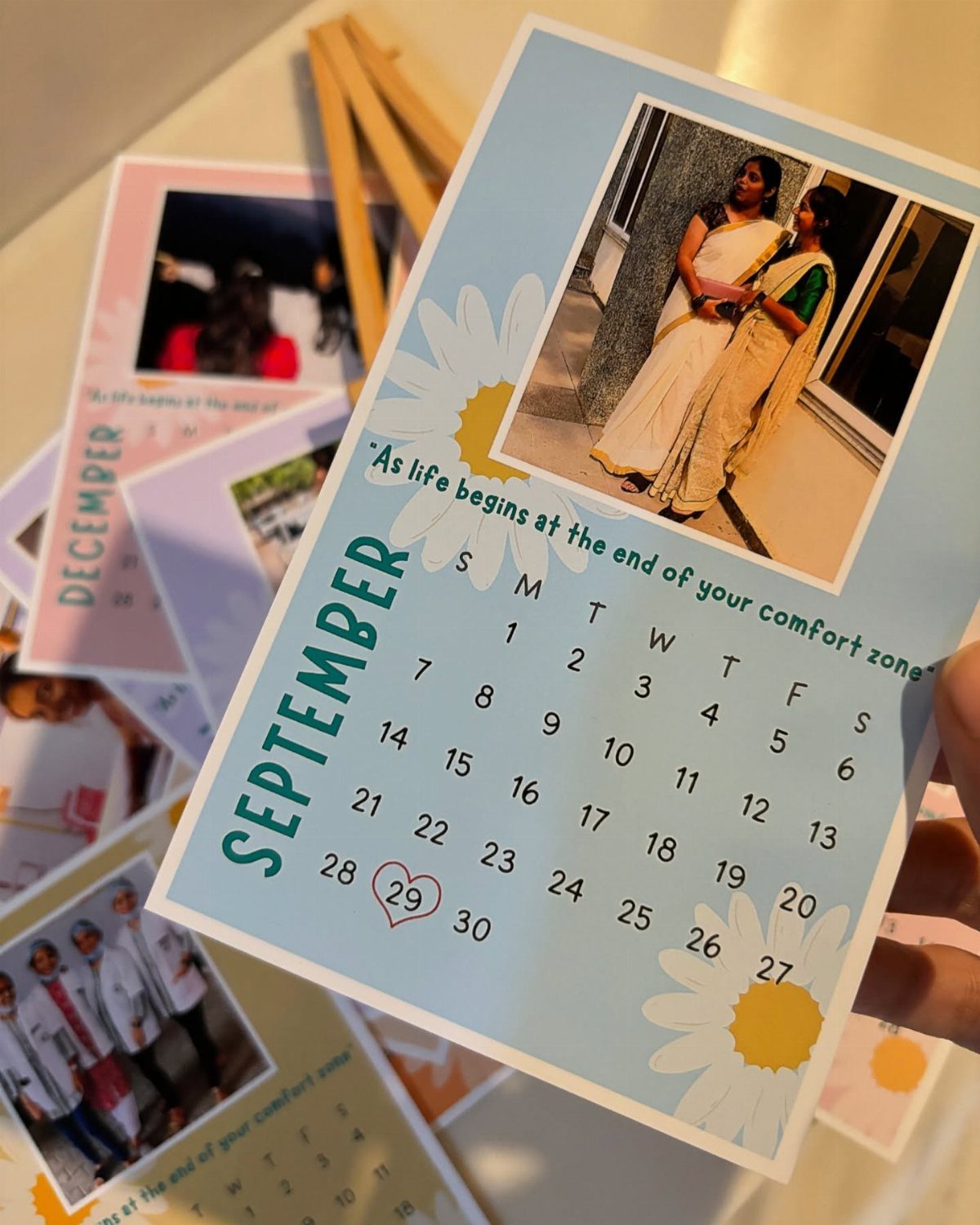 Personalized September calendar page with a photo of two women and daisy decorations.