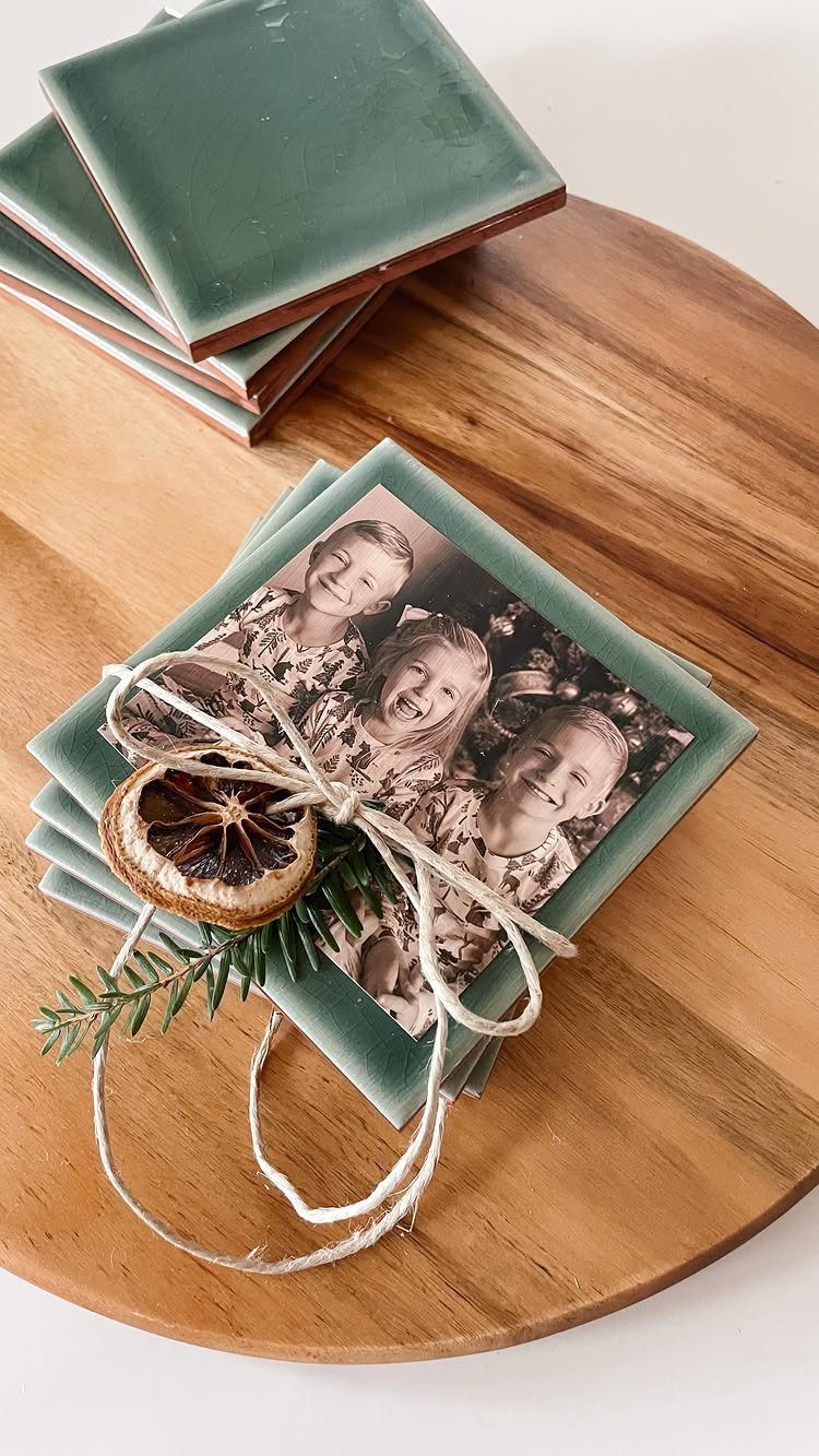 Sage green ceramic tile coasters with a photo of children tied with twine.