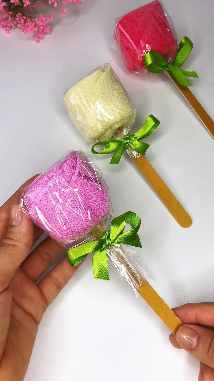 Rolled colorful towels wrapped in plastic and tied to sticks like lollipops.