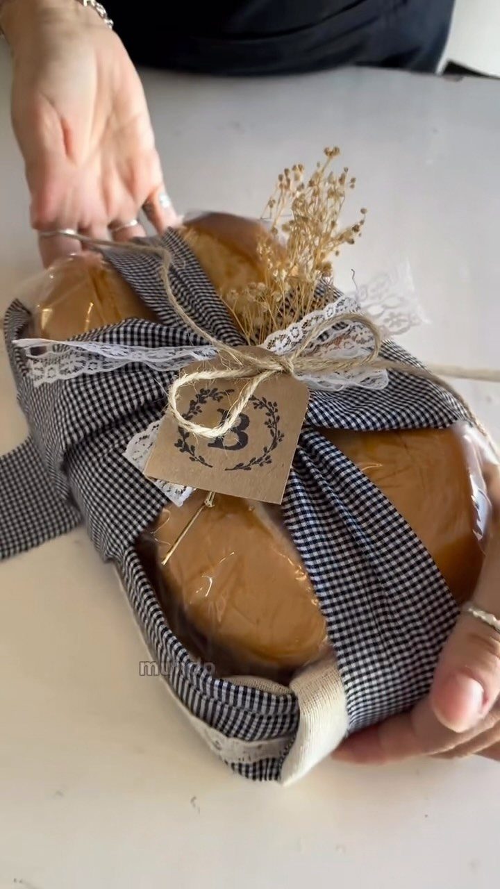 Gift wrapped in blue checkered fabric containing baked goods with a gift tag.