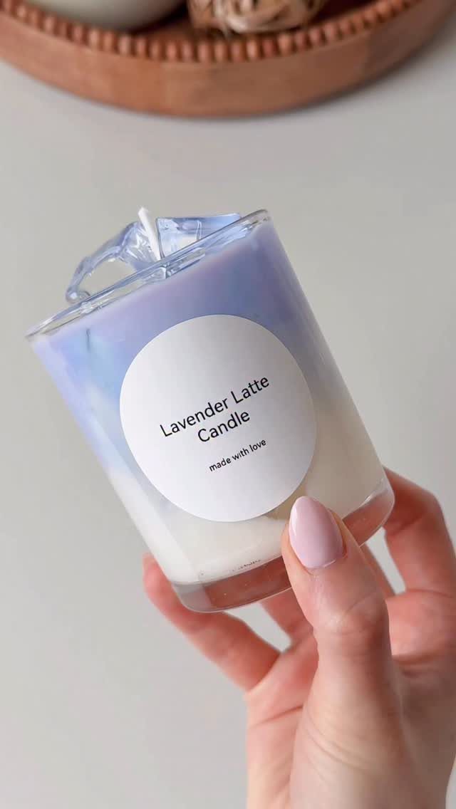 Lavender Latte Candle in a glass jar held by a hand with pink nails.