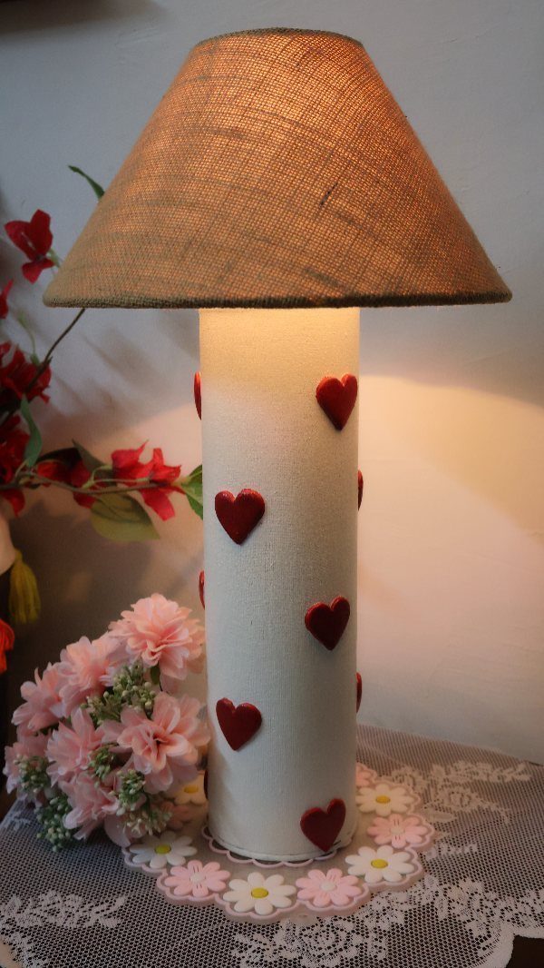 White cylindrical lamp decorated with red hearts and a brown burlap shade.