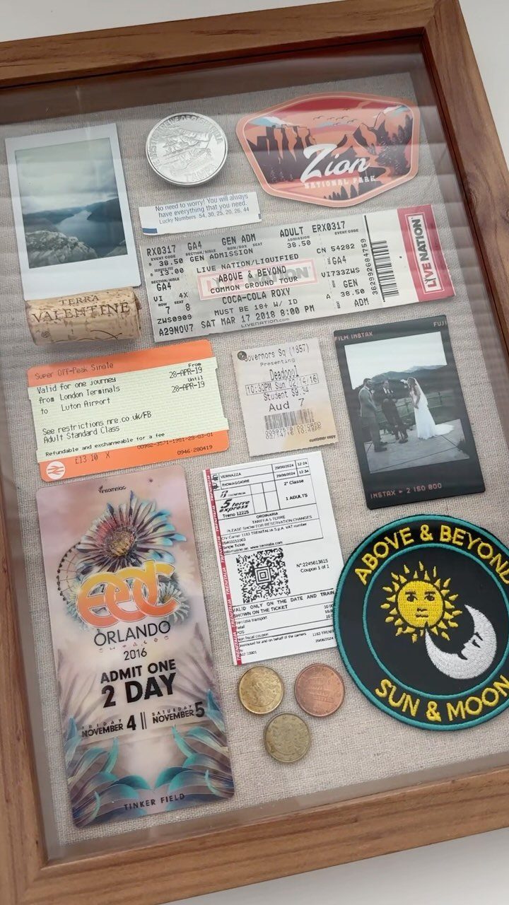 Wooden shadow box filled with travel mementos, photos, tickets, and a national park patch.