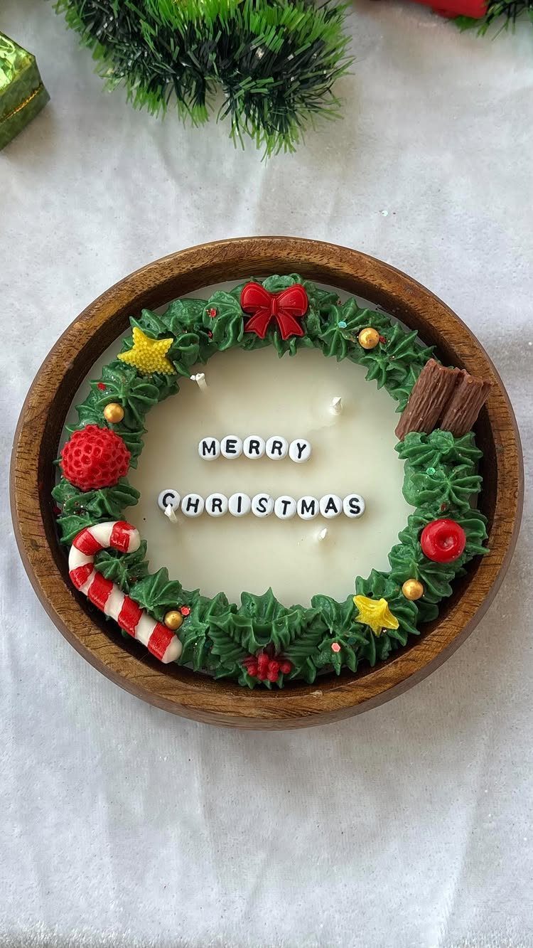 White Christmas candle in a wooden bowl decorated with a green wax wreath