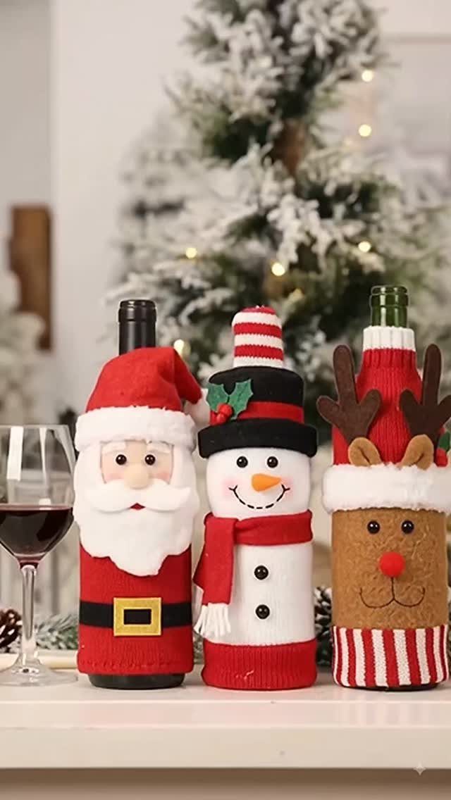 Three wine bottles wearing knitted holiday sweaters as Santa, a snowman, and a reindeer.