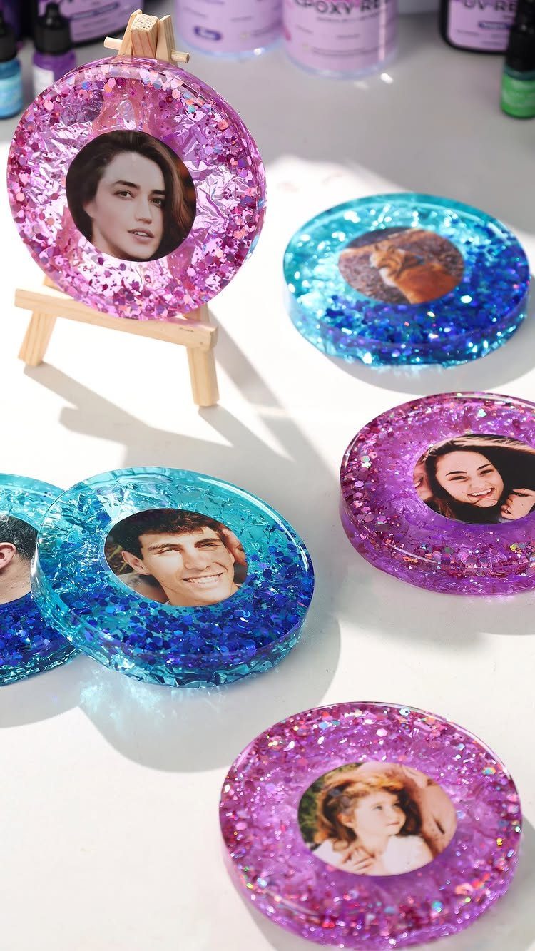 Glittery resin coasters with embedded portrait photos in pink and blue colors.