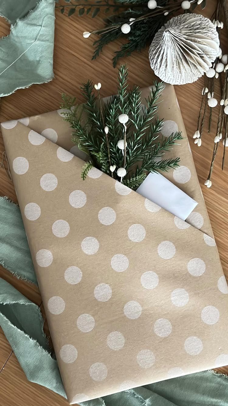 Polka dot wrapped gift with a built-in pocket holding a card and pine sprig.
