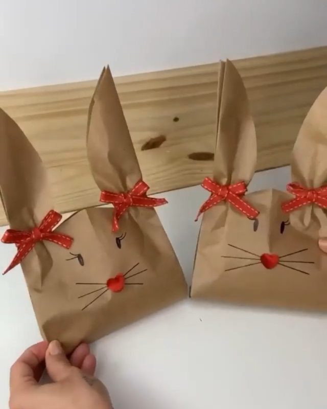 Bunny rabbit gift bags made from brown wrapping paper with red bows.
