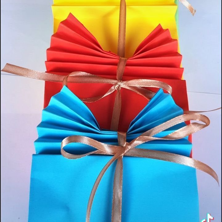 Colorful blue, red, and yellow paper gift bags tied with gold ribbons.