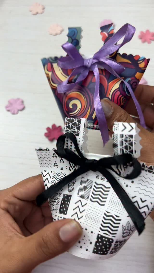 Two small handmade gift bags with colorful and geometric patterns and ribbon bows.