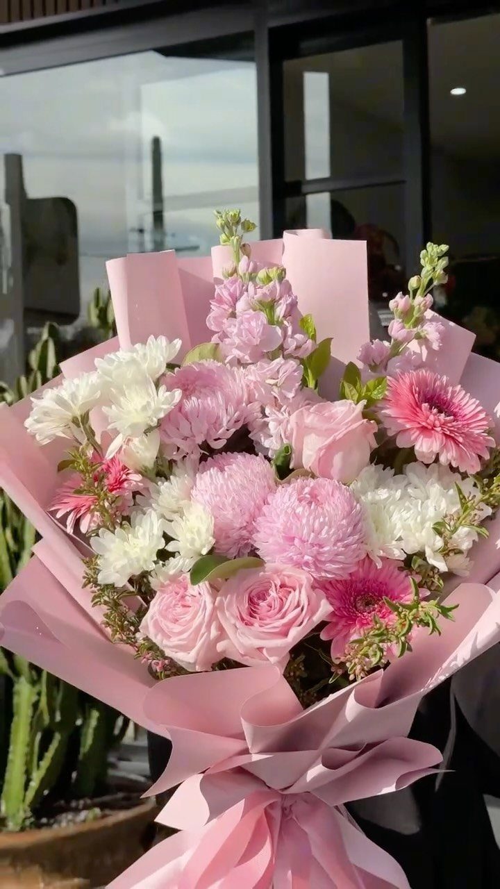 Pink and white flower bouquet wrapped in light pink paper in a fan shape