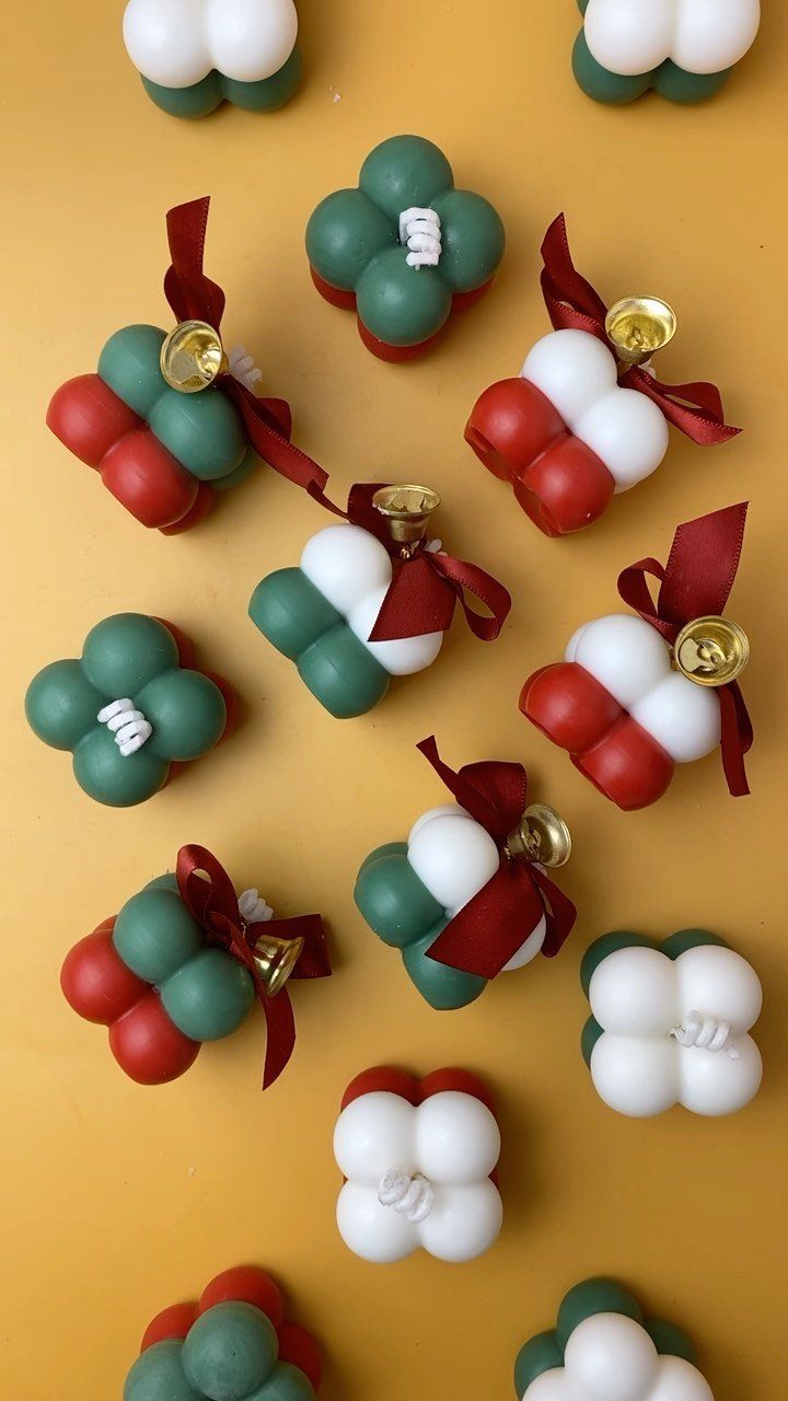 Cluster-shaped Christmas ornaments in red, green, and white on a yellow background.