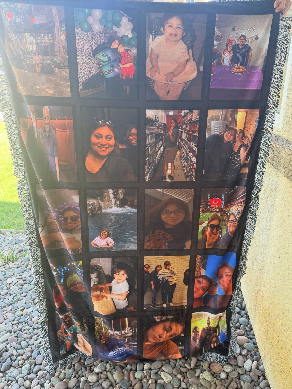 Custom photo blanket with a grid of family pictures held outdoors over pebbles.