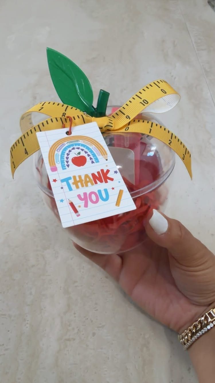 Apple-shaped gift container with a thank you tag and measuring tape ribbon.